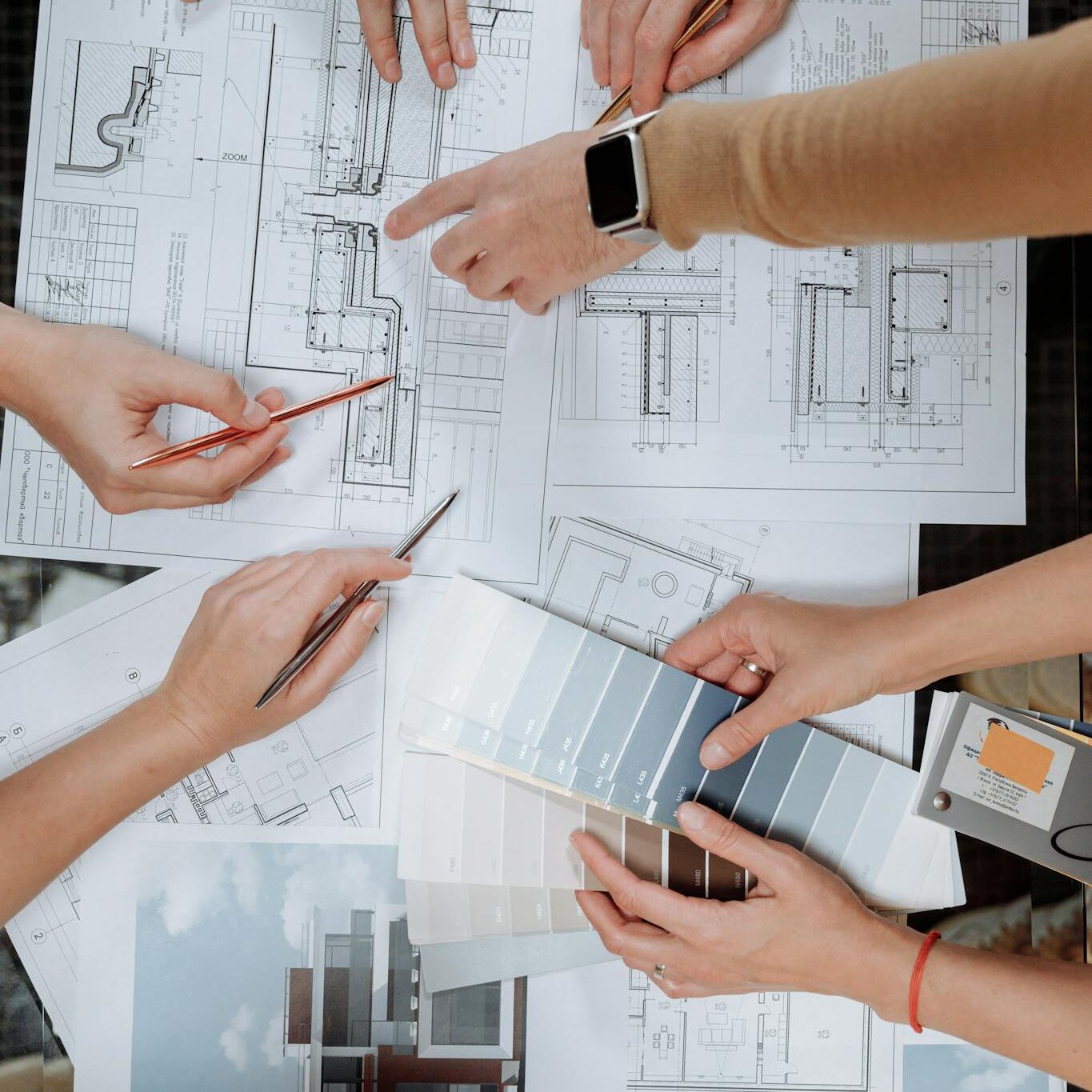 Team working together on architectural blueprints and color swatches.